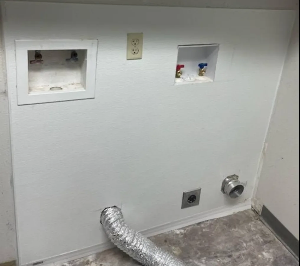 Finished laundry hookup and utility installation wall